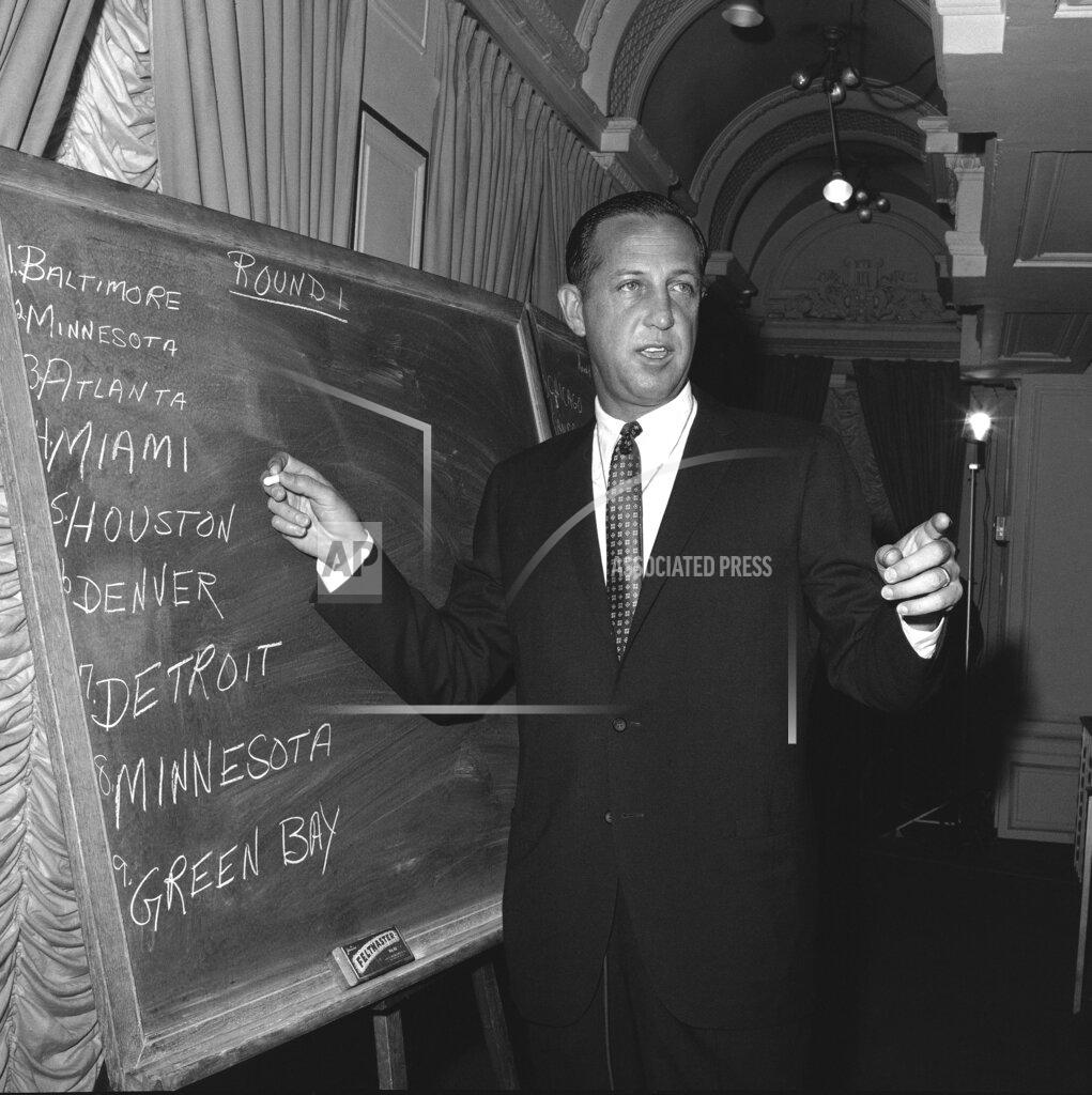 Jacob Harris FILE - In this March 14, 1967, file photo, Pete Rozelle, professional football commissioner, works at on a blackboard at a New York City hotel during the first round of the combined National Football League (NFL) - American Football league (AFL) football player draft. ESPN approached NFL Commissioner Pete Rozelle in 1980 offering to broadcast the proceedings of the NFL Draft from the New York Sheraton. Rozelle couldn’t fathom why ESPN boss Chet Simmons made the offer. “Pete thought Chet was out of his mind,” said former ESPN vice president John Wildhack. “But Pete said, ‘Let’s try it.” (AP Photo/Jacob Harris, File)