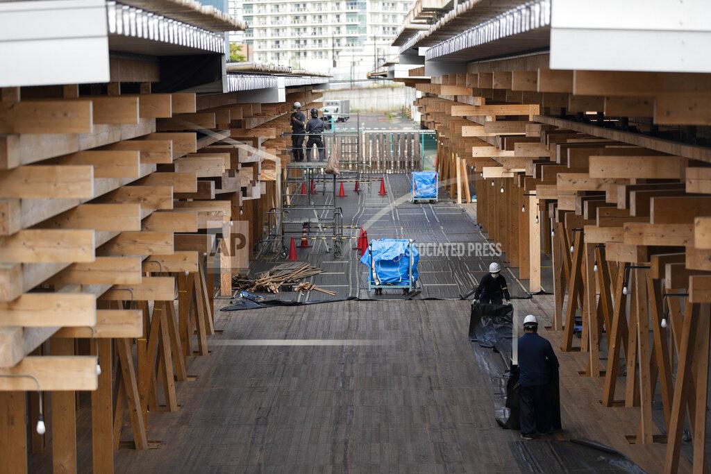 Hiro Komae Construction workers fold a tarp sheet at a closed building complex being built as part of the athletes' village to be used during the postponed Tokyo 2020 Olympic and Paralympic Games, in Tokyo Thursday, April 8, 2021. Many preparations are still up in the air as organizers try to figure out how to hold the postponed games in the middle of a pandemic. (AP Photo/Hiro Komae)