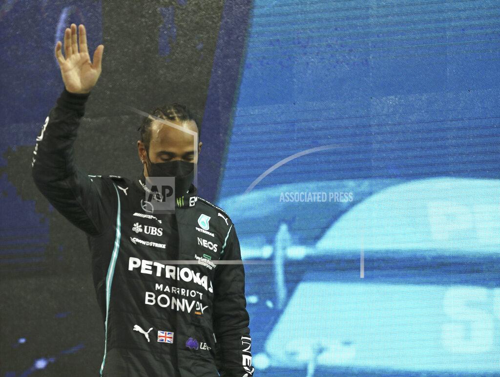 Kamran Jebreili Mercedes driver Lewis Hamilton of Britain looks down as he walks onto the podium after finishing second in the Formula One Abu Dhabi Grand Prix in Abu Dhabi, United Arab Emirates, Sunday, Dec. 12. 2021. Max Verstappen ripped a record eighth title away from Lewis Hamilton with a pass on the final lap of the Abu Dhabi GP to close one of the most thrilling Formula One seasons in years as the first Dutch world champion. (AP Photo/Kamran Jebreili, Pool)