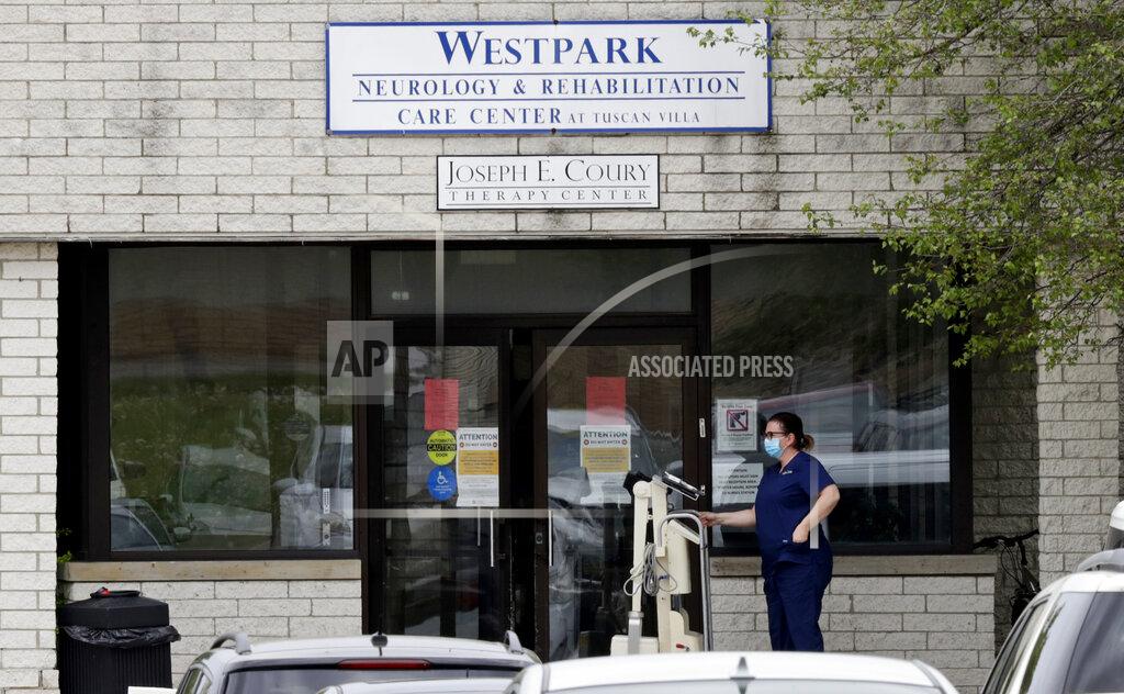 Tony Dejak A woman waits to enter the Westpark Neurology and Rehabilitation Center with a medical device, Tuesday, May 19, 2020, in Cleveland. The number of deaths from the coronavirus in Ohio's nursing homes is now over 1,000. That means long-term centers account for three out of five deaths from the virus in the state. Westpark Neurology and Rehabilitation Center has at least 75 cumulative resident cases and 17 cumulative staff cases. (AP Photo/Tony Dejak)