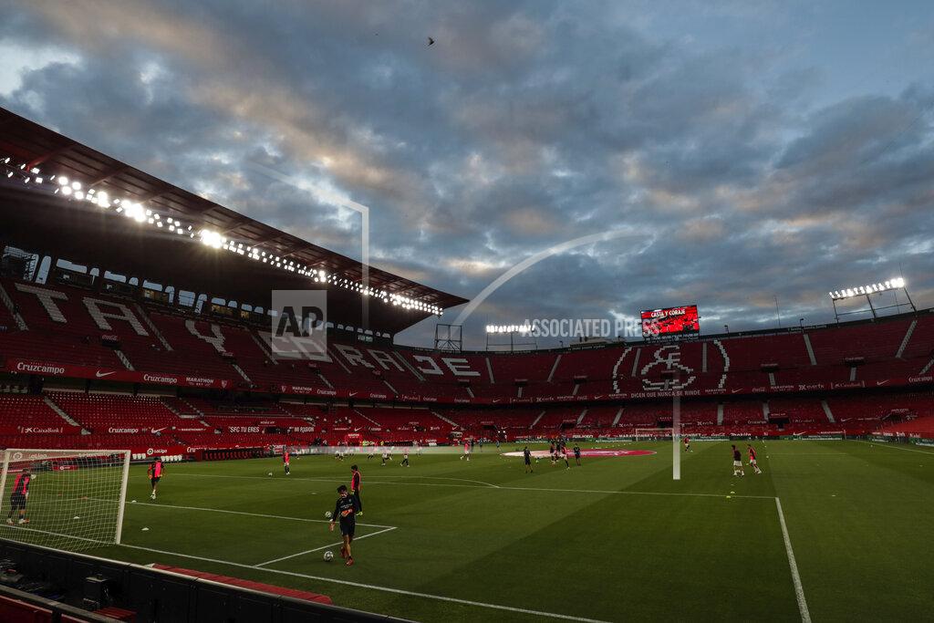Str Sevilla and Betis players warm up before the start of their Spanish La Liga soccer match in Seville, Spain, Thursday, June 11, 2020. With virtual crowds, daily matches and lots of testing for the coronavirus, soccer is coming back to Spain. The Spanish league resumes this week more than three months after it was suspended because of the pandemic, becoming the second top league to restart in Europe. The Bundesliga was first. The Premier League and the Italian league should be next in the coming weeks. (AP Photo)
