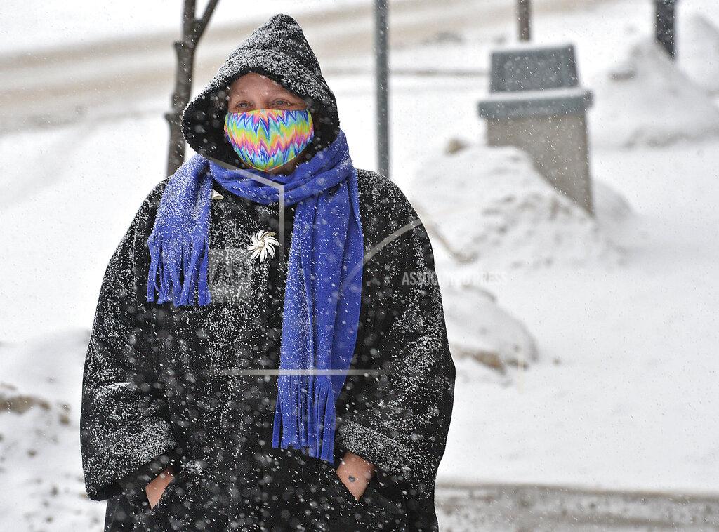 Christopher Millette Diane Phelps, 54, walks along Main Street in Girard, Pa., during a morning snowfall on Monday, Feb. 15, 2021. A storm expected in northwest Pennsylvania and western New York region is predicted to drop up several inches of snow by Tuesday afternoon. (Christopher Millette/Erie Times-News via AP)