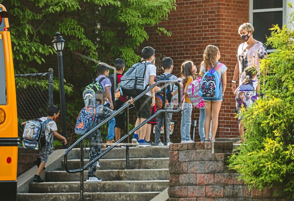 Andrew Rush Students arrive masked to Memorial Elementary School, Tuesday, Aug. 24, 2021, in Bethel Park, Pa., a Pittsburgh suburb. In a heated school board meeting the previous evening, the Bethel Park School District voted to amend the district's health and safety plan and require all students, staff and visitors to wear masks inside the district's schools. (Andrew Rush/Pittsburgh Post-Gazette via AP)