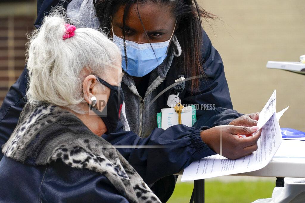Mary Altaffer A nurse goes over the vaccination card with Sarah Luisi, of Uniondale, N.Y., before inoculating her with the Johnson & Johnson's one-dose COVID-19 vaccine at the Vaxmobile, at the Uniondale Hempstead Senior Center, Wednesday, March 31, 2021, in Uniondale, N.Y. The Vaxmobile, is a COVID-19 mobile vaccination unit, sponsored by a partnership between Mount Sinai South Nassau and Town of Hempstead to bring the one-dose vaccine directly to hard-hit communities in the area. (AP Photo/Mary Altaffer)