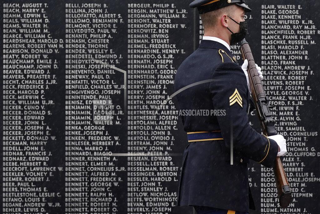 Patrick Semansky A member of an honor guard walks past names on a memorial wall during a Memorial Day event attended by President Joe Biden at Veterans Memorial Park at the Delaware Memorial Bridge in New Castle, Del., Sunday, May 30, 2021. (AP Photo/Patrick Semansky)
