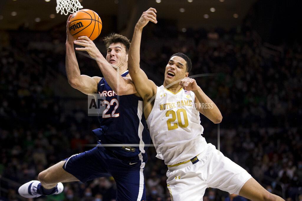 Robert Franklin Virginia's Francisco Caffaro (22) grabs a rebound next to Notre Dame's Paul Atkinson Jr. (20) during the second half of an NCAA college basketball game Saturday, Jan. 29, 2022, in South Bend, Ind. (AP Photo/Robert Franklin)