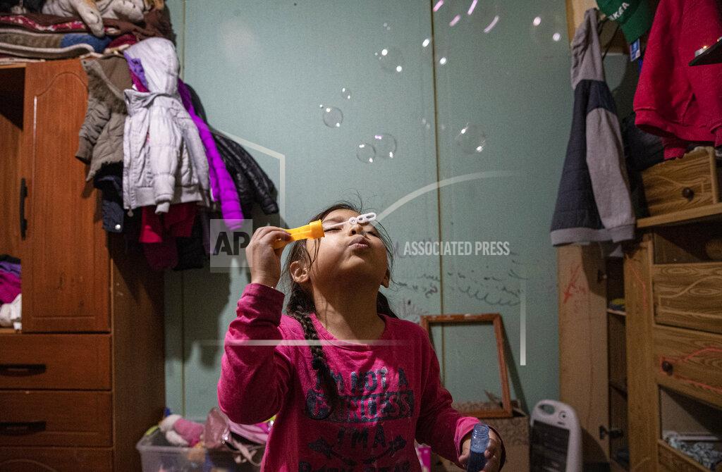 Esteban Felix Kehity Collantes blows soap bubbles before going to bed in her home where she lives with her father and aunt in Santiago, Chile, Monday, Aug. 17, 2020, two months after her mother Silvia Cano died of COVID-19. Kehity's mother was hospitalized with pneumonia in May when Chile was going through some of the worst days of its pandemic with around 4,000 new cases reported daily. (AP Photo/Esteban Felix)
