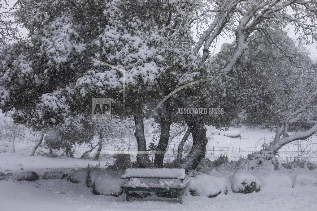 Ariel Schalit A bench is covered in snow at a memorial site near the Quneitra border crossing between Syria and the Israeli-controlled Golan Heights, Wednesday, Feb. 17, 2021. (AP Photo/Ariel Schalit)