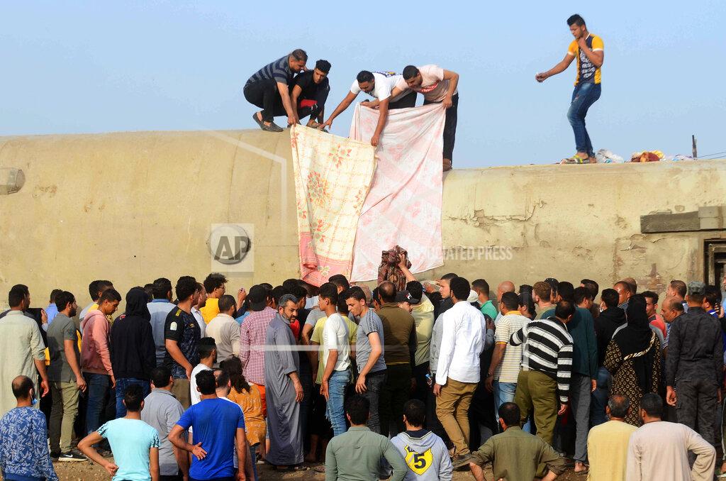 Tarek Wagih People gather at the site where a passenger train derailed injuring at least 100 people, near Banha, Qalyubia province, Egypt, Sunday, April 18, 2021. At least eight train wagons ran off the railway, the provincial governor's office said in a statement. (AP Photo/Tarek Wagih)