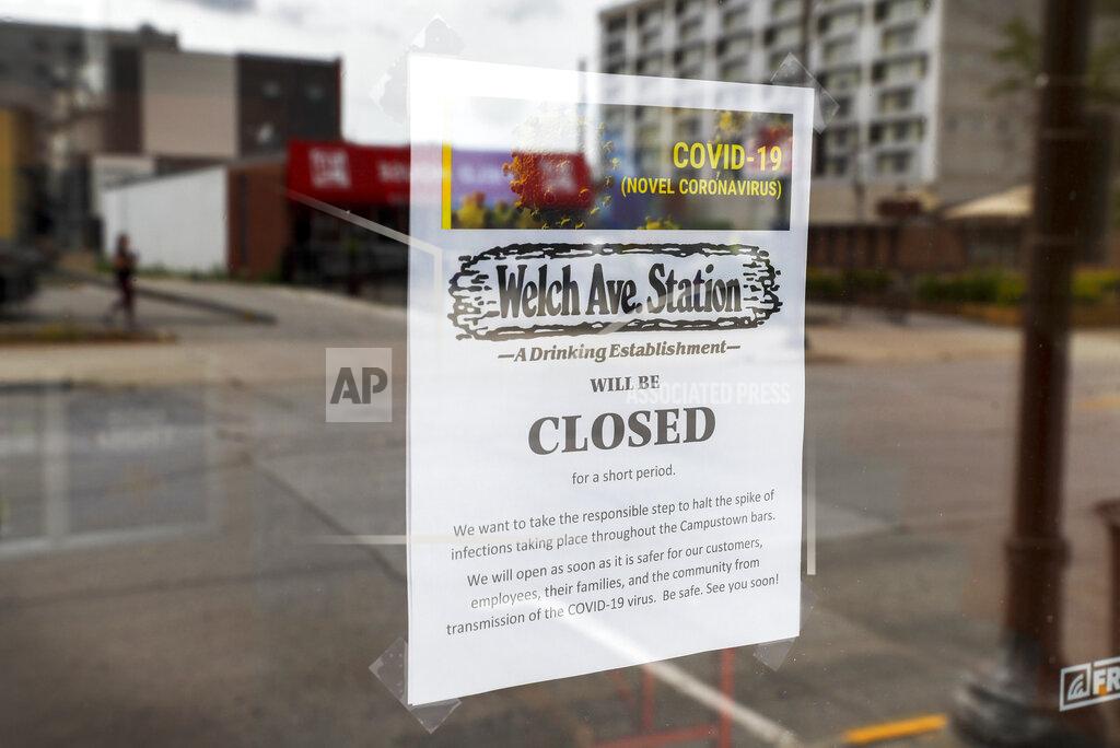 Charlie Neibergall A closed sign is seen in the front window of the Welch Ave Station bar, Tuesday, June 23, 2020, in Ames, Iowa. Within a few weeks of Gov. Kim Reynolds opening bars and restaurants to customers again two major college cities in Iowa are seeing spikes in coronavirus cases among young adults between 19 and 25, reflecting similar trends seen in other states including Florida and Texas. In Ames the surge is serious enough to prompt several owners of restaurants and bars near the Iowa State University campus to close voluntarily just weeks after reopening. (AP Photo/Charlie Neibergall)