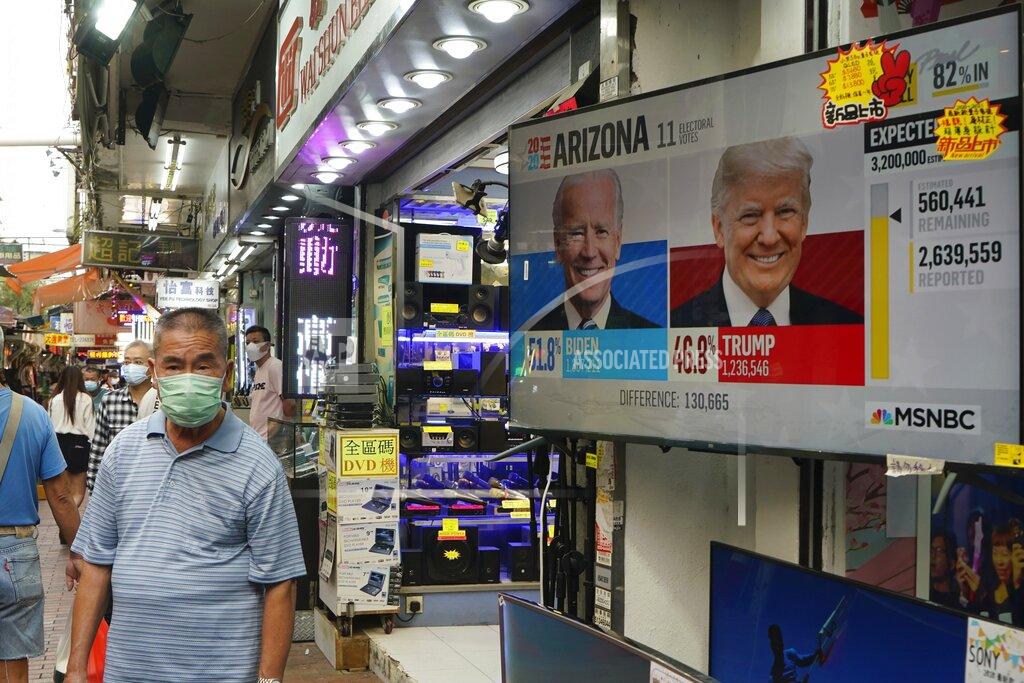 Kin Cheung A man walks past a TV monitor showing a news program reporting the U.S. presidential election between President Donald Trump, right, and former Vice President Joe Biden, left, in Hong Kong, Wednesday, Nov. 4, 2020. ( AP Photo/Kin Cheung)
