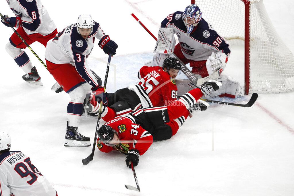 Jeff Haynes Chicago Blackhawks center Carl Soderberg (34) and teammate Andrew Shaw (65) collide while going for the puck as Columbus Blue Jackets defenseman Seth Jones (3) and goaltender Elvis Merzlikins (90) defend during the third period of an NHL hockey game Sunday, Jan. 31, 2021, in Chicago. (AP Photo/Jeff Haynes)