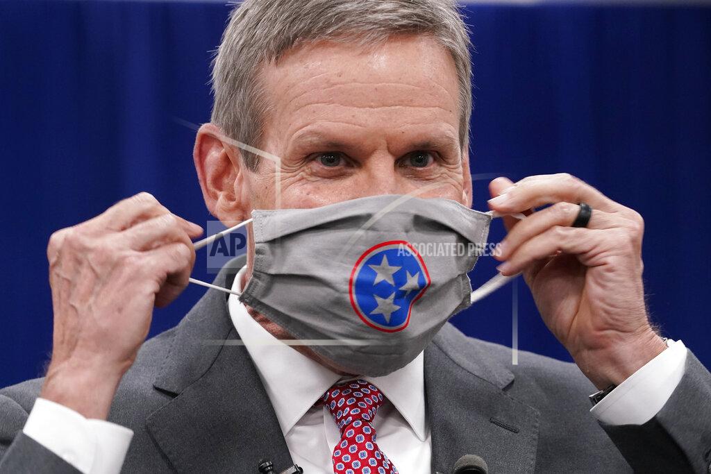 Tennessee Gov. Bill Lee puts on his mask during a break in the state budget hearings Tuesday, Nov. 10, 2020, in Nashville, Tenn. According to a Vanderbilt University School of Medicine study released Tuesday, Tennessee counties that have not required wearing masks in public are on average seeing COVID-19 death rates double or more compared with those that instituted mandates. Lee has opposed a statewide mask mandate, stressing personal responsibility. He has instead allowed counties to decide whether to require masks. (AP Photo/Mark Humphrey)