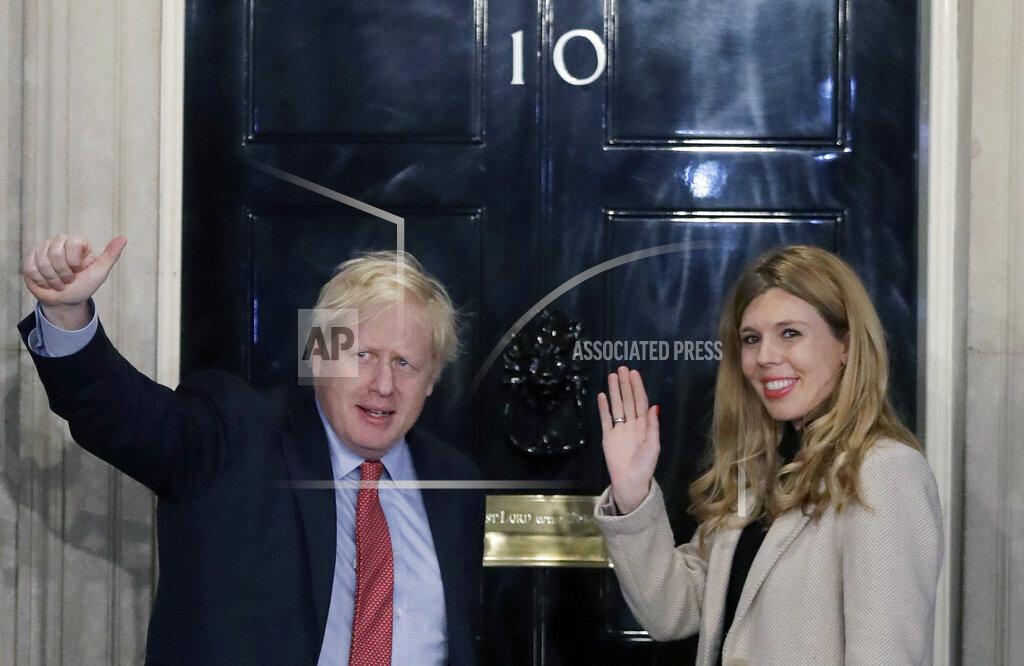FILE -In this Friday, Dec. 13, 2019 file photo, Britain's Prime Minister Boris Johnson and his partner Carrie Symonds wave from the steps of number 10 Downing Street in London. Boris Johnson and his partner Carrie Symonds have announced she gave birth to a "healthy baby boy at a London hospital earlier this morning”, Wednesday April 29, 2020, saying that both mother and baby are doing well. (AP Photo/Matt Dunham, file)