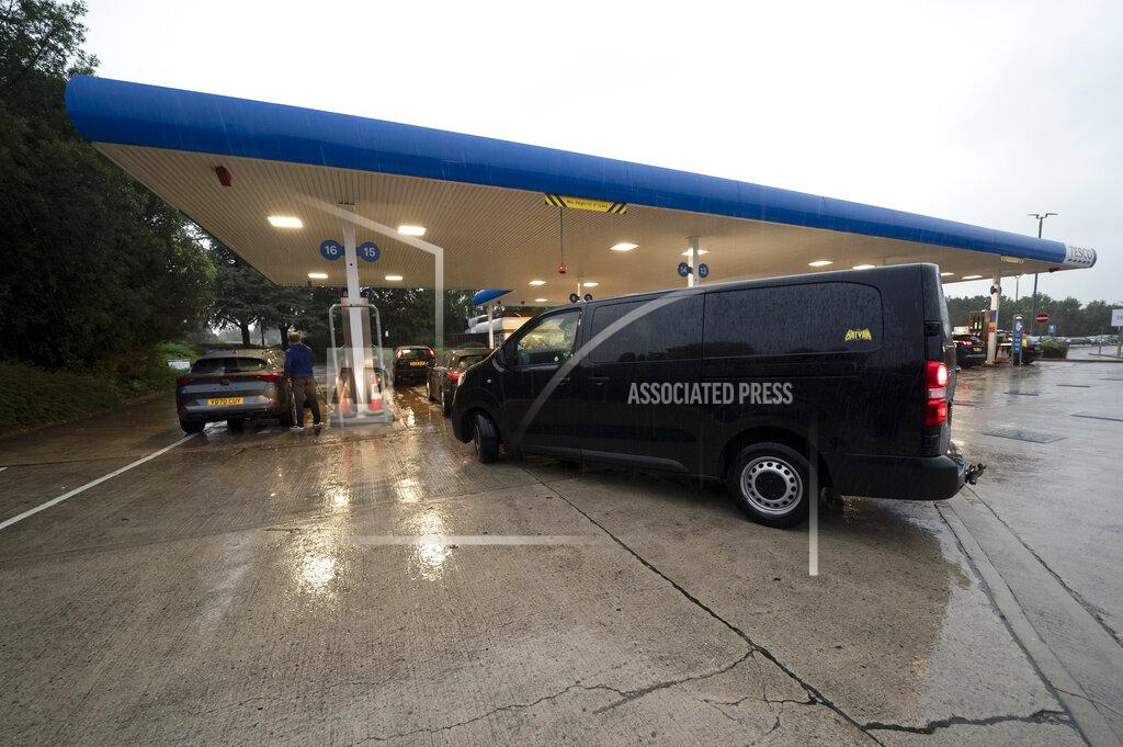 Jon Super Vehicles fill up at a petrol station after an outbreak of panic buying in the UK, in Manchester, England, Monday, Sept. 27, 2021. British Prime Minister Boris Johnson is said to be considering whether to call in the army to deliver fuel to petrol stations as pumps ran dry after days of panic buying. ( AP Photo/Jon Super)