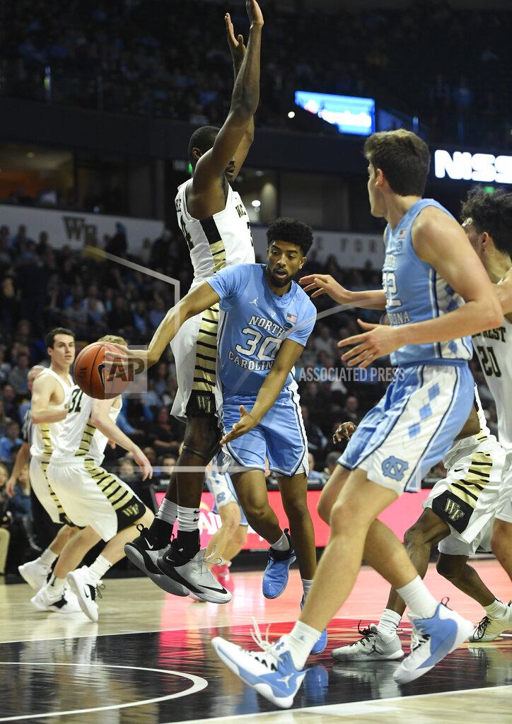 Woody Marshall North Carolina's K.J. Smith (30) makes a pass to his teammate under the basket as Wake Forest's Sunday Okeke (34) tries to defend during the second half of an NCAA college basketball game in Winston-Salem, N.C., Saturday, Feb 16, 2019. (AP Photo/Woody Marshall)