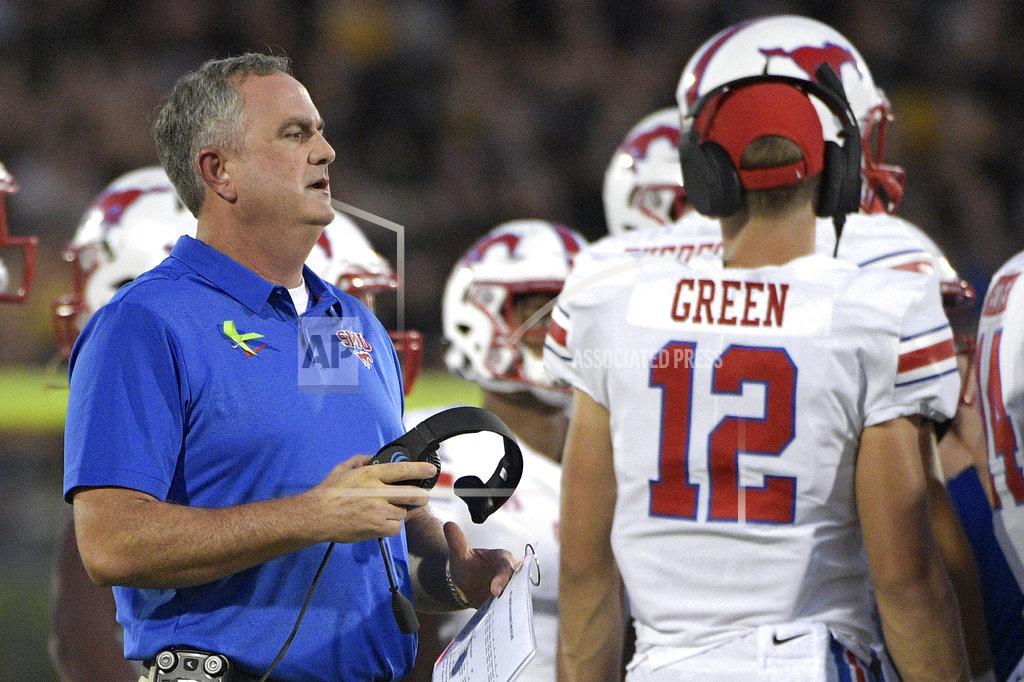Phelan M. Ebenhack SMU head coach Sonny Dykes, left, talks to his players during a timeout in the first half of an NCAA college football game against Central Florida Saturday, Oct. 6, 2018, in Orlando, Fla. (AP Photo/Phelan M. Ebenhack)