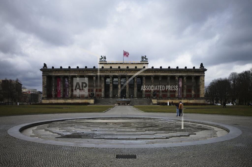 Markus Schreiber Only a few people stay on the Lustgarten place in front of the 'Alte Museum', Old Museum, of the 'Museumsinsel', Museums Island, in Berlin, Germany, Monday, March 15, 2021. Museums throughout Germany closed at the beginning of November as coronavirus cases increased. Under new regulations, some of the collections on Berlin's Museum Island, one of the city's cultural highlights and a UNESCO World Heritage site, are now allowed to re-open to visitors. (AP Photo/Markus Schreiber)