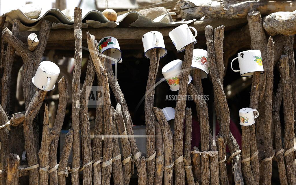 Fernando Vergara FILE - In this Sept. 10, 2015 file photo, mugs hang to dry on a fence outside the home of a Wayuu family in Manaure, Colombia. A human rights group released a report Thursday, Aug. 13, 2020, warning that lack of access to clean water is leading to alarmingly high levels of child mortality and malnutrition among the Wayuu, Colombia’s largest Indigenous group. (AP Photo/Fernando Vergara, File)