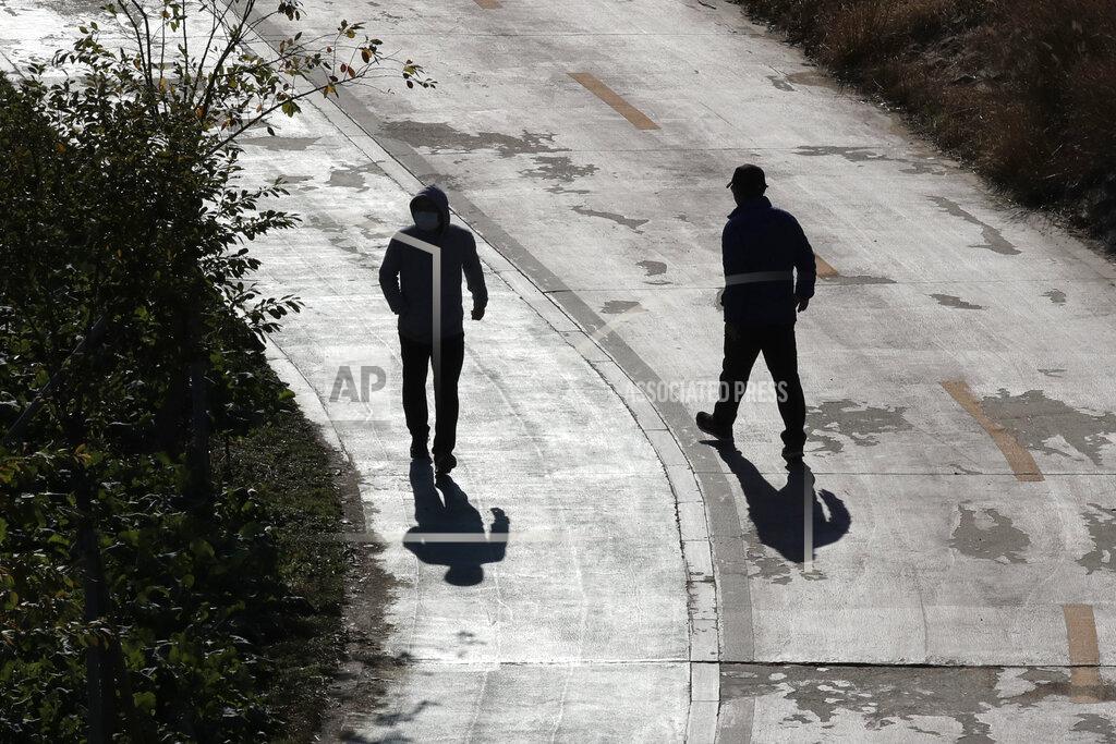 Lee Jin-Man Visitors wearing face masks to help cub the spread of the coronavirus, are silhouetted near a public area along a stream in Seoul, South Korea, Monday, Nov. 23, 2020. (AP Photo/Lee Jin-man)
