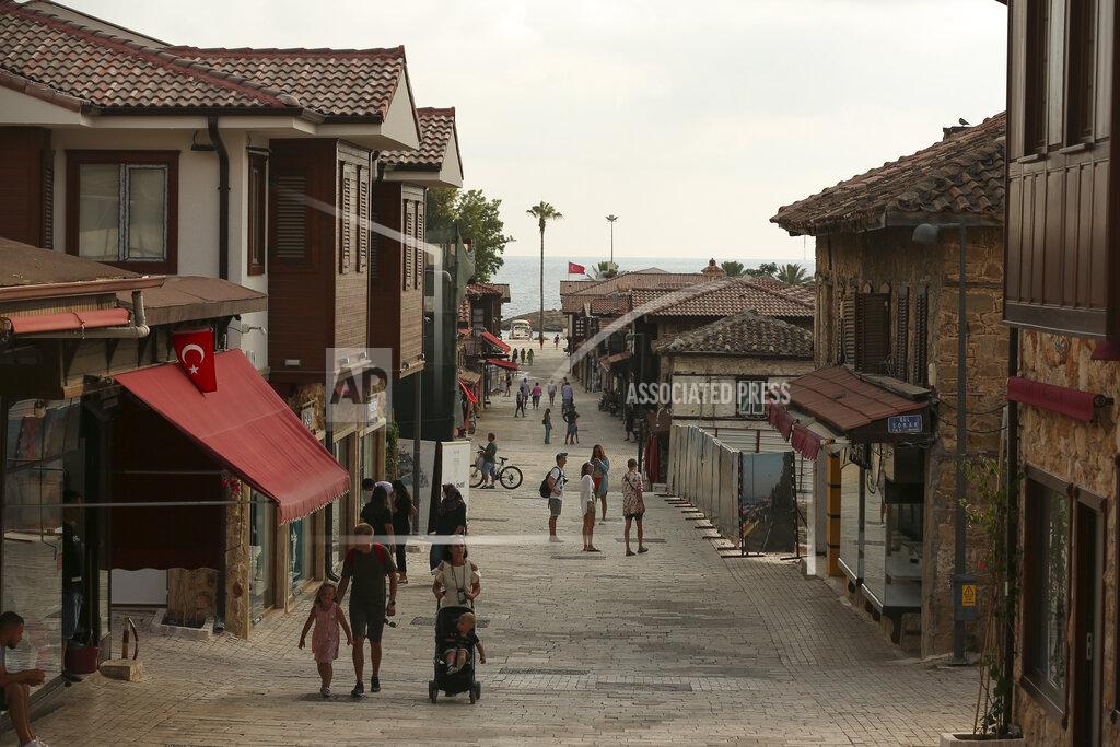 Emrah Gurel Tourists walk on the city of Antalya, southern Turkey, on Sunday, June 20, 2021. Hotels in Turkey's Antalya region, a destination beloved by holidaymakers, are preparing to finally resume operations as they expect the return of international tourists after months of setbacks caused by the pandemic that halted travel. (AP Photo/Emrah Gurel)