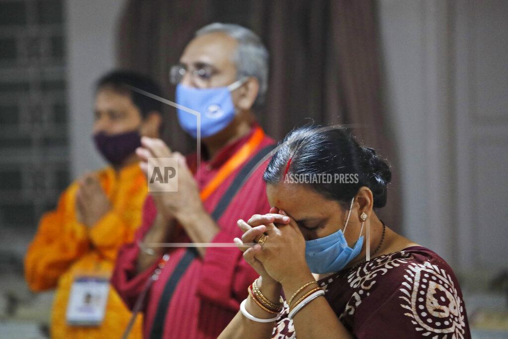 Manish Swarup Members of the festival organizing team at the Kali Bari Hindu temple pray via live transmission on the first day of Durga Puja celebrations in New Delhi, India, Thursday, Oct. 22, 2020. Most of the festival festivities are being scaled down following the health officials warning about the potential for the coronavirus to spread during the religious festival season, which is marked by huge gatherings in temples and shopping districts. (AP Photo/Manish Swarup)