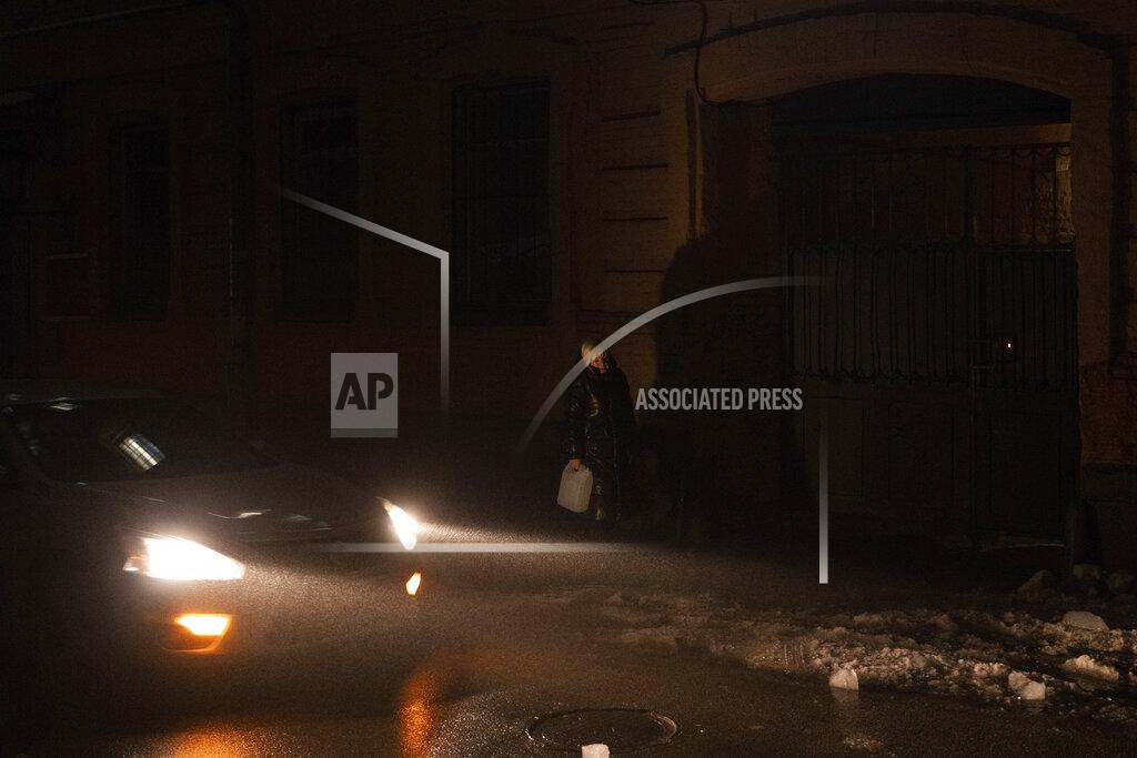 Evgeniy Maloletka A woman carries a bucket with water at the city center which lost electrical power after yesterday's Russian rocket attack in Kyiv, Ukraine, Thursday, Nov. 24, 2022. (AP Photo/Evgeniy Maloletka)