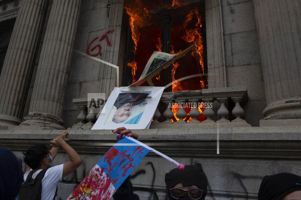 Oliver De Ros An official photo of former Congress President Eduardo Meyer is thrown out from the Congress building after protesters set a part of the building on fire, in Guatemala City, Saturday, Nov. 21, 2020. Hundreds of protesters were protesting in various parts of the country Saturday against Guatemalan President Alejandro Giammattei and members of Congress for the approval of the 2021 budget that reduced funds for education, health and the fight for human rights. (AP Photo/Oliver De Ros)