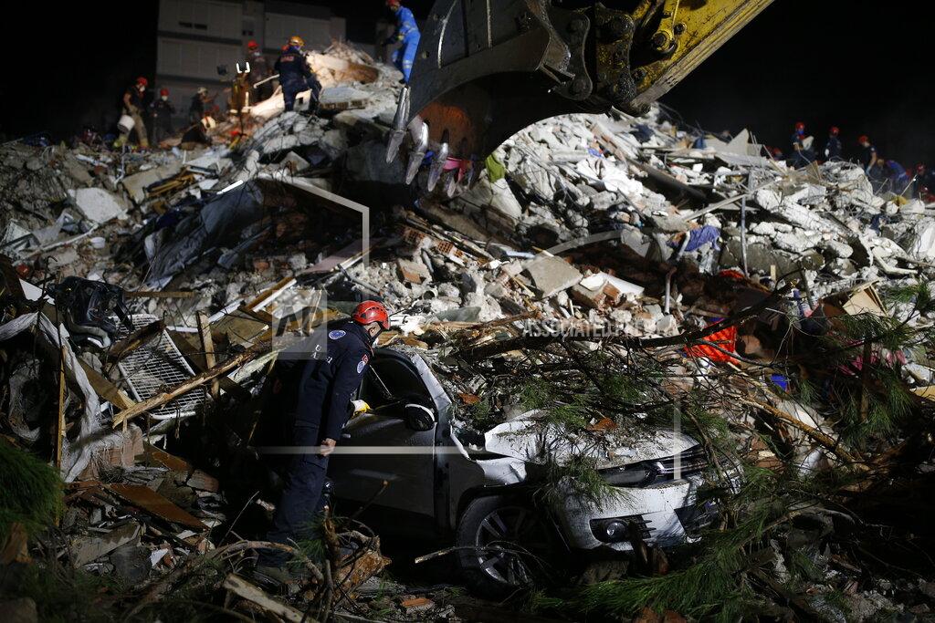 Emrah Gurel Members of rescue services search a destroyed car amidst the debris of a collapsed building in Izmir, Turkey, early Saturday, Oct. 31, 2020. A strong earthquake struck Friday in the Aegean Sea between the Turkish coast and the Greek island of Samos, killing several people and injuring hundreds amid collapsed buildings and flooding. (AP Photo/Emrah Gurel)