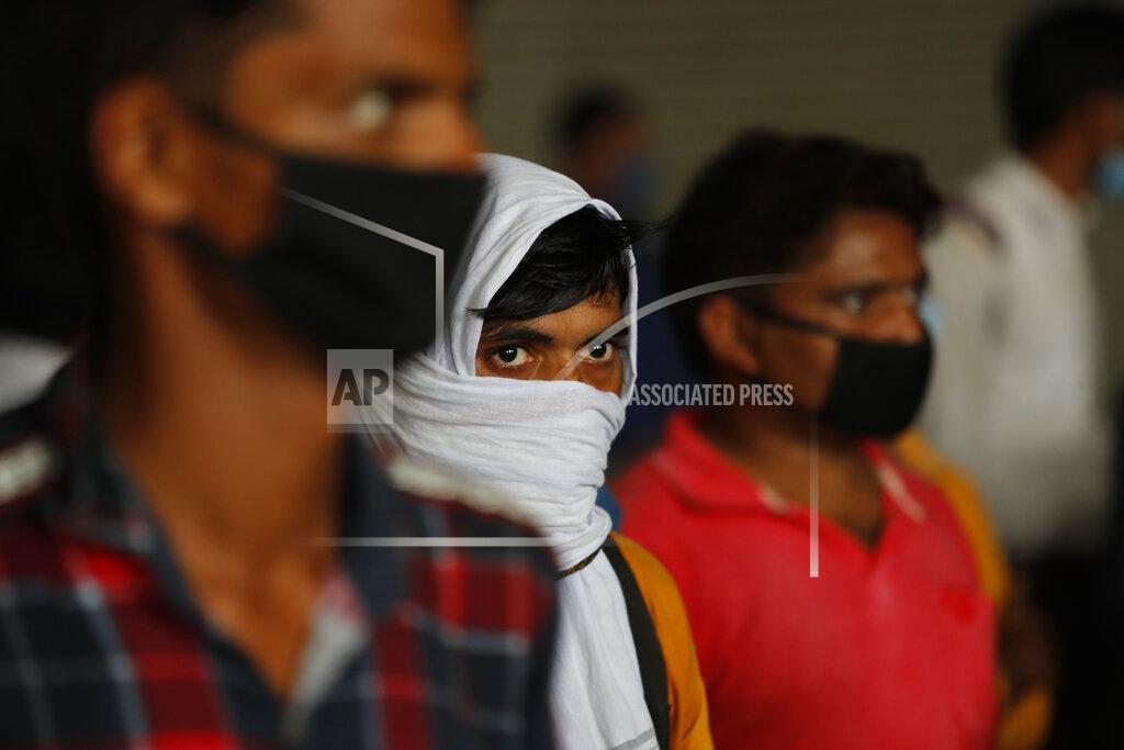 Manish Swarup Migrant workers wait to get their COVID-19 tests done as they return to look for jobs in New Delhi, India, Tuesday, Aug. 18, 2020. The lockdown imposed in late March cost more than 10 million impoverished migrant workers their jobs in the cities. Many made grueling journeys back to their hometowns and villages. Now they face the ordeal of trying to get back to their factory jobs. India's pandemic assistance has amounted to only about 1% of its GDP, Nobel laureate Abhijit Banerjee said, compared with the U.S.'s package in March of about 10% of its GDP. (AP Photo/Manish Swarup)