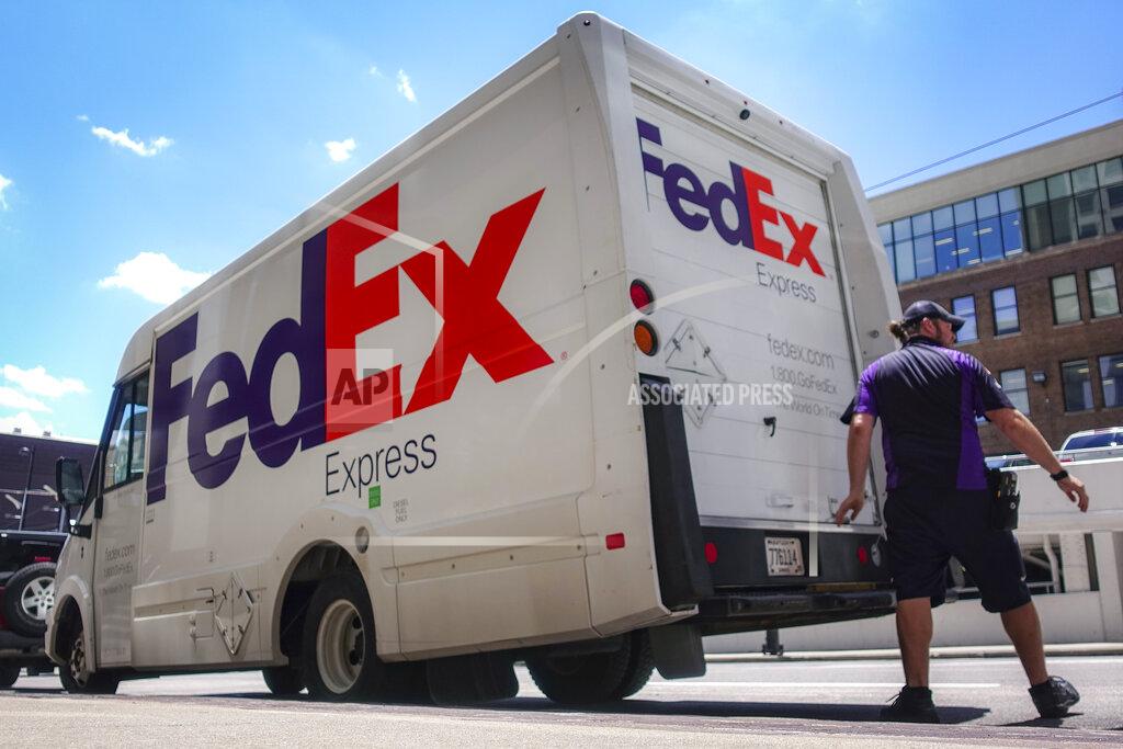 FILE - In this June 25, 2019, file photo, a FedEx delivery truck is loaded by an employee on the street in downtown Cincinnati. FedEx is off to a fast start during the holiday-shipping season. The company said Thursday, Dec. 17, 2020, that its quarterly profit more than doubled to $1.23 billion. Revenue is up 19%, led by growth in its ground business that handles packages. (AP Photo/John Minchillo, File)
