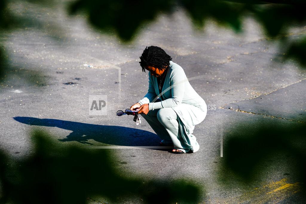 Matt Rourke FILE - A woman pauses outside the scene of a shooting at a supermarket, in Buffalo, N.Y., Sunday, May 15, 2022. A white man is accused of shooting 13 people Saturday at the Tops Friendly Market in a predominantly Black neighborhood of Buffalo. Long before an 18-year-old avowed white supremacist inflicted terror at a Buffalo supermarket, the city's Black neighborhoods, like many others around the nation, had been dealing with wounds that are generations old. (AP Photo/Matt Rourke, File)
