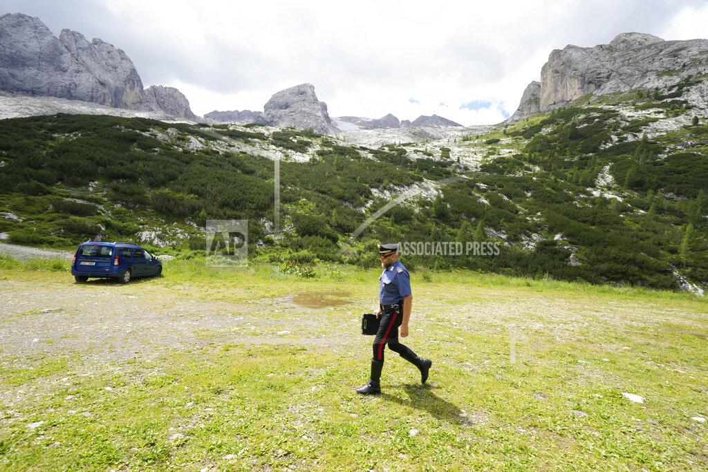 Luca Bruno A Carabinieri officer checks a car parked at the foot of the Punta Rocca glacier near Canazei, in the Italian Alps in northern Italy, Tuesday, July 5, 2022, and believed to belong to victims of the glacier avalanche that broke loose on Sunday, sending tons of ice, snow, and rocks onto hikers. (AP Photo/Luca Bruno)