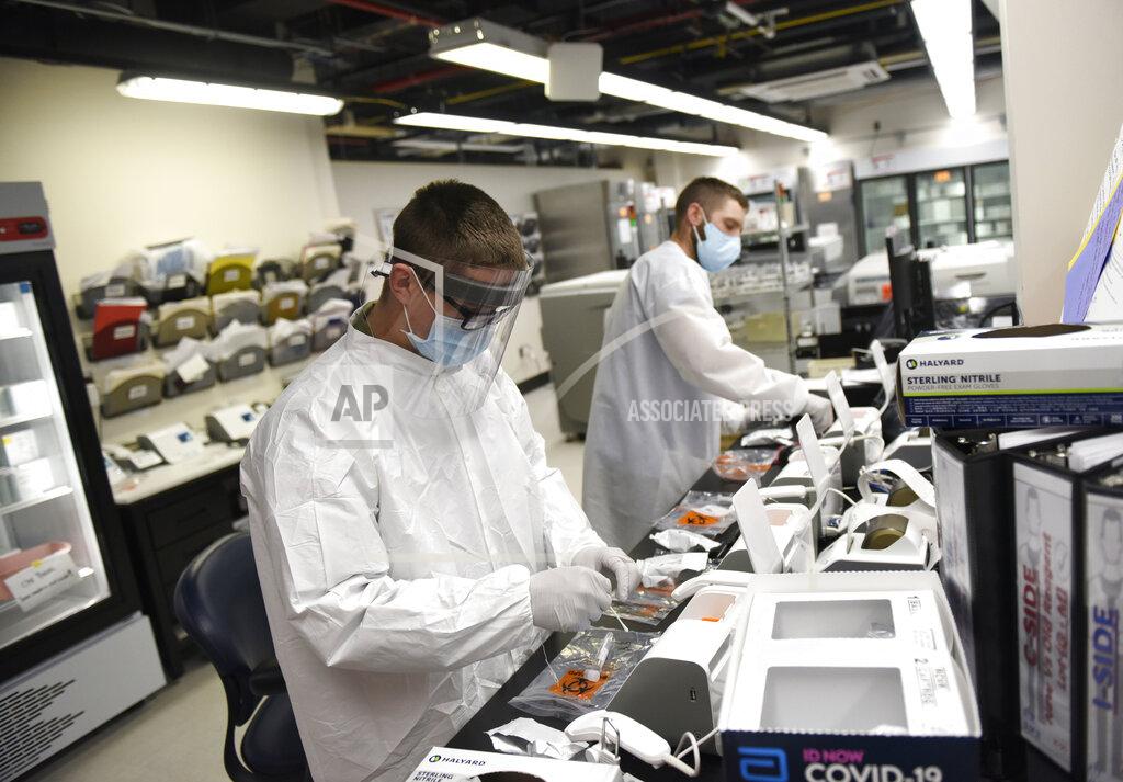 Tyler Sizemore FILE - In this May 14, 2020, file photo, Sgt. Nick Spencer, who is part of the U.S. Army Urban Augmentation Medical Task Force, left, and medical laboratory scientist Dyllon Reilly run coronavirus tests in the lab at Stamford Hospital in Stamford, Conn. On Tuesday, Sept. 29, 2020, Connecticut Gov. Ned Lamont said that Connecticut expects to receive about 1 million new rapid tests for the new coronavirus from the federal government and will use them to help make sure schools stay open. (Tyler Sizemore/Hearst Connecticut Media via AP, File)