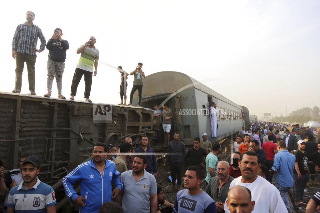 Fadel Dawood People gather at the site where a passenger train derailed injuring at least 100 people, in Banha, Qalyubia province, Egypt, Sunday, April 18, 2021. At least eight train wagons ran off the railway, the provincial governor's office said in a statement. (AP Photo/Fadel Dawood)