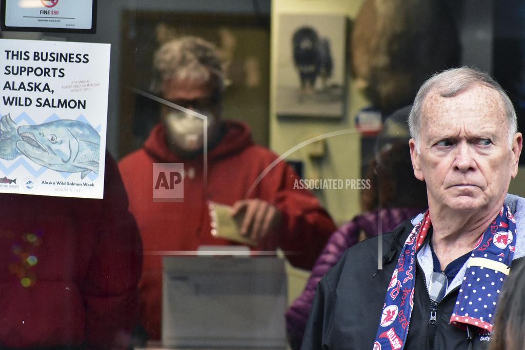 Peter Segall A man stands outside Art Sutch's photography store in downtown Juneau on Friday, April 24, 2020. Sutch, background, decided to close his downtown location of 25 years due to the lack of a tourist season because of COVID-19. Sutch said in a Facebook post he would continue photography, digital and printing work at a personal studio. (Peter Segall/Juneau Empire via AP)