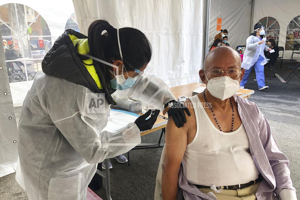 Haven Daley FILE - In this Feb. 8, 2021, file photo, Victor Villegas, 78, right, receives a COVID-19 vaccine shot from a health care worker at a vaccination site in the Mission district of San Francisco. As Newsom faces a likely recall, Latino advocates say engaging their communities and providing a more robust response to the pandemic could be keys to his survival. (AP Photo/Haven Daley, File)