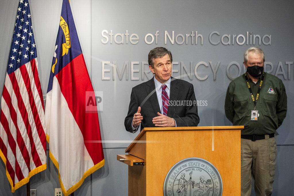 Travis Long Gov. Roy Cooper speaks as Director of NC Emergency Management Mike Sprayberry looks on during a briefing on North Carolina's coronavirus pandemic response Wednesday, Jan. 27, 2021 at the NC Emergency Operations Center in Raleigh.(Travis Long/The News & Observer via AP)
