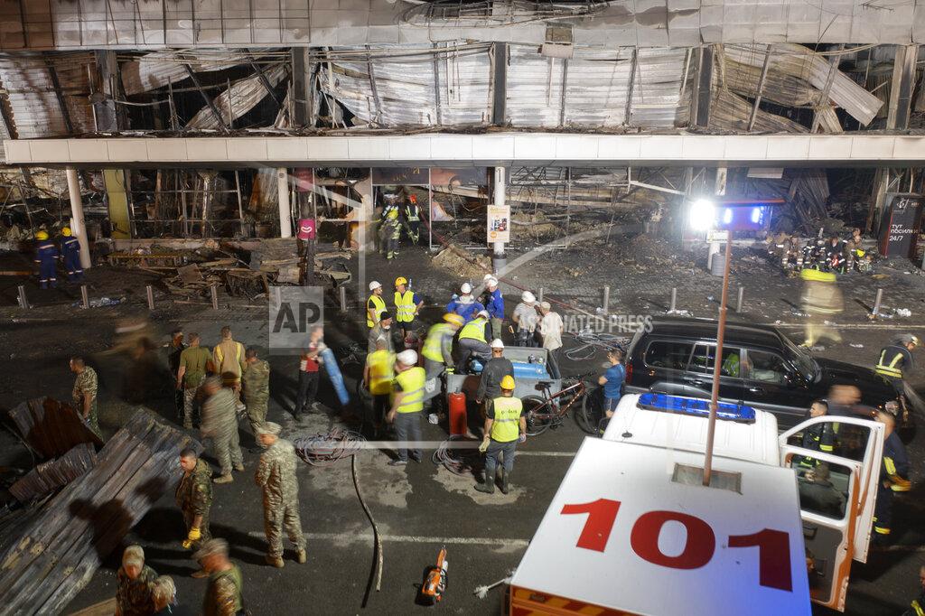 Efrem Lukatsky Ukrainian State Emergency Service firefighters work to take away debris at a shopping center burned after a rocket attack in Kremenchuk, Ukraine, Monday, June 27, 2022. Residents of the quiet, riverside city of Kremenchuk are reeling in the wake of a Russian airstrike that obliterated a shopping mall and killed at least 18. With dozens still missing, psychologists are working with families to help them through their grief and toward acceptance that they may never find their loved ones. (AP Photo/Efrem Lukatsky)