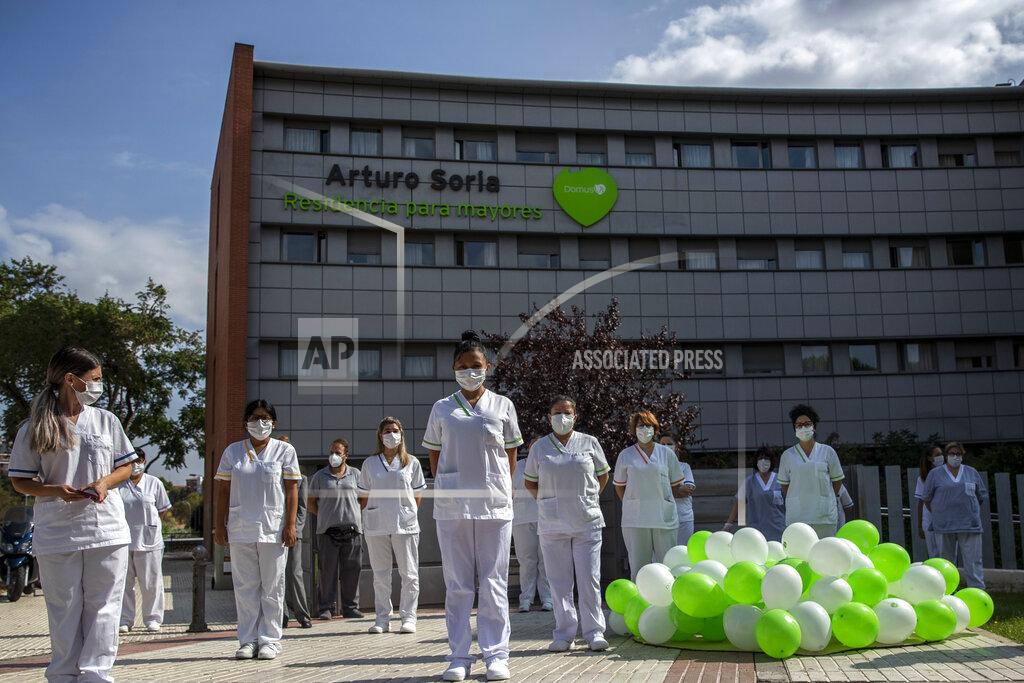 Workers of a nursing home "DomusVi Arturo Soria" hold a minute of silence in support of the social and health sector and its workers in Madrid, Spain, Tuesday, Sept. 15, 2020. After ending a strict lockdown in June having brought under control the virus transmission, Spain is now the European country where a second wave of the contagion is being more noticed. (AP Photo/Manu Fernandez)