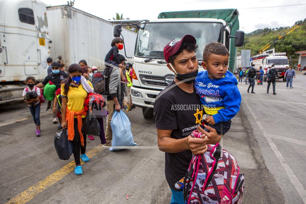 Oliver De Ros Honduran migrants walk to the border crossing after being transported in an army truck to El Florido, Guatemala, a border point between Guatemala and Honduras, Tuesday, Jan. 19, 2021. A once large caravan of Honduran migrants that pushed its way into Guatemala last week had dissipated by Tuesday in the face of Guatemalan security forces. (AP Photo/Oliver de Ros)