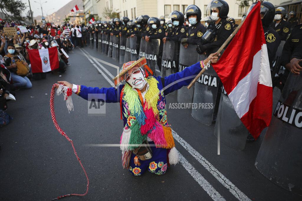 Rodrigo Abd Local folk artists perform next to a police line outside Congress building, as they wait for news from inside on who will be the country's next president, in Lima, Peru, Sunday, Nov. 15, 2020. Interim President Manuel Merino announced his resignation following massive protests unleashed when lawmakers ousted President Martin Vizcarra. (AP Photo/Rodrigo Abd)