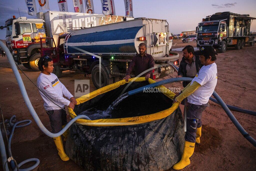 Bernat Armangue In this Thursday, Jan. 9, 2020 photo, Karcher staffers fill a tank with water to be used for cleaning vehicles at the bivouac of the Dakar Rally in Hail, Saudi Arabia. Formerly known as the Paris-Dakar Rally, the race was created by Thierry Sabine after he got lost in the Libyan desert in 1977. Until 2008, the rallies raced across Africa, but threats in Mauritania led organizers to cancel that year's event and move it to South America. It has now shifted to Saudi Arabia. The race started on Jan. 5 with 560 drivers and co-drivers, some on motorbikes, others in cars or in trucks. Only 41 are taking part in the Original category. (AP Photo/Bernat Armangue)