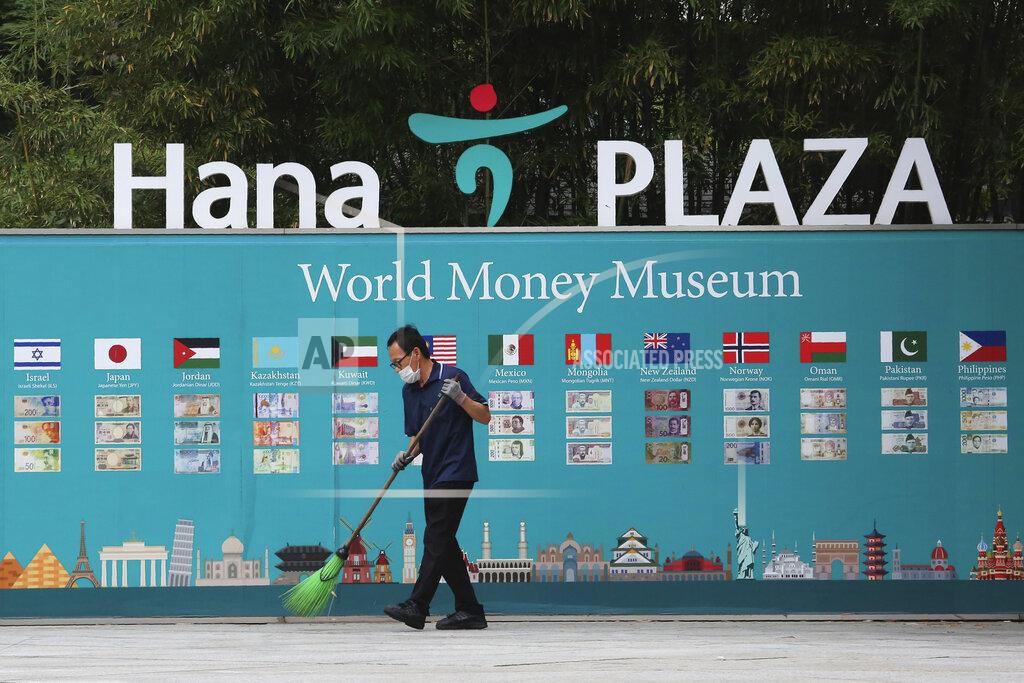 Ahn Young-Joon A worker wearing a face mask to help protect against the spread of the new coronavirus cleans near a bank's currency advertisement board in Seoul, South Korea, Friday, June 26, 2020. (AP Photo/Ahn Young-joon)