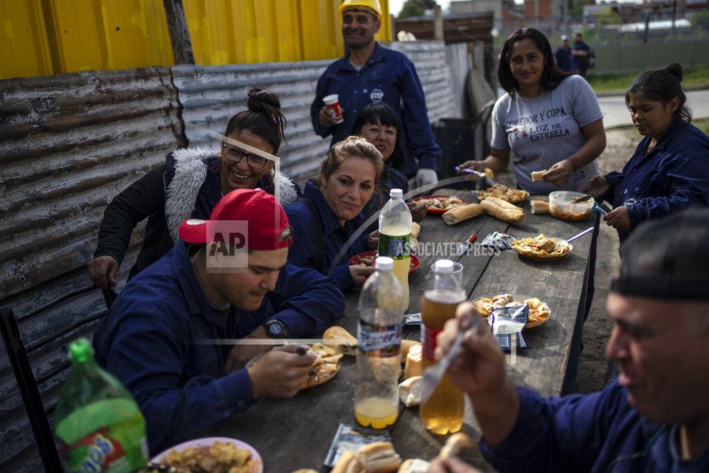 Rodrigo Abd Residents, some working on community construction projects, eat at a local soup kitchen in the Puerta de Hierro neighborhood, in La Matanza district of Buenos Aires, Argentina, Wednesday, May 11, 2022. Argentines have lived with double-digit inflation for years, but the latest increase in prices is causing more to rely on food aid. (AP Photo/Rodrigo Abd)
