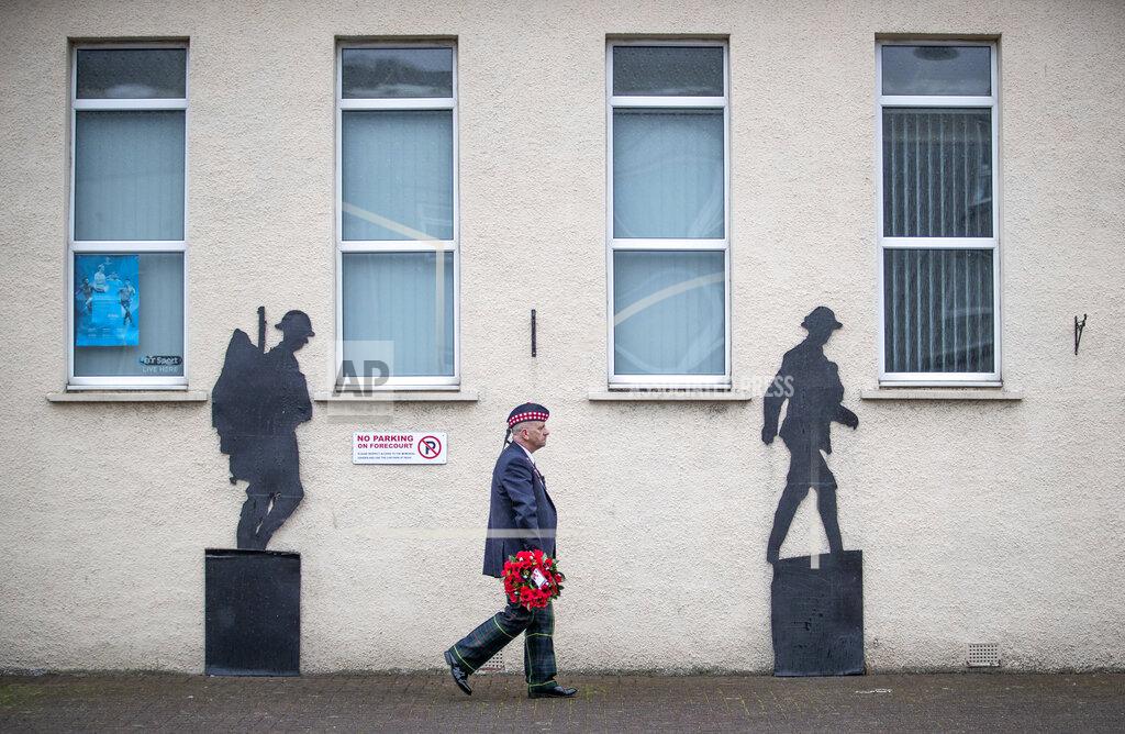 Jane Barlow Veteran Charlie MacVicar, who served for 23 years with the Royal Scots (Edinburgh Unit), walks past the Royal British Legion on his way to lay a wreath at the Remembrance Garden on Remembrance Sunday, in Grangemouth, Scotland, Sunday, Nov. 8, 2020. (Jane Barlow/PA via AP)