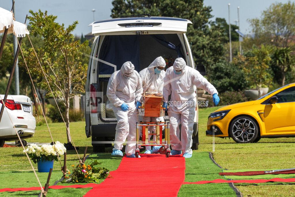 Jerome Delay Pallbearers wearing full PPE suits lift the casket containing the remains of Benedict Somi Vilakasi for his burial ceremony at the Nasrec Memorial Park outside Johannesburg Thursday, April 16, 2020. Vilakasi, a Soweto coffee shop manager, died of Covid-19 infection in a Johannesburg hospital Sunday April 12 2020. South Africa is under a strict five-week lockdown in a effort to fight the Coronavirus pandemic.(AP Photo/Jerome Delay)
