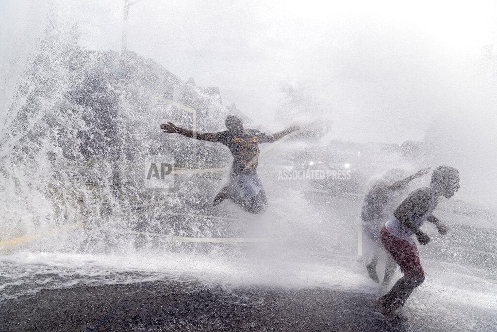 David Goldman Children play in the spray of an open fire hydrant on a hot summer day in the Auburn Gresham neighborhood in Chicago, Wednesday, Aug. 26, 2020. As summer arrived, shootings surged in the 6th police district, which includes Auburn Gresham. Over three months, there were a shocking 175 victims. The youngest, 10 and 11, were wounded in a drive-by attack. (AP Photo/David Goldman)