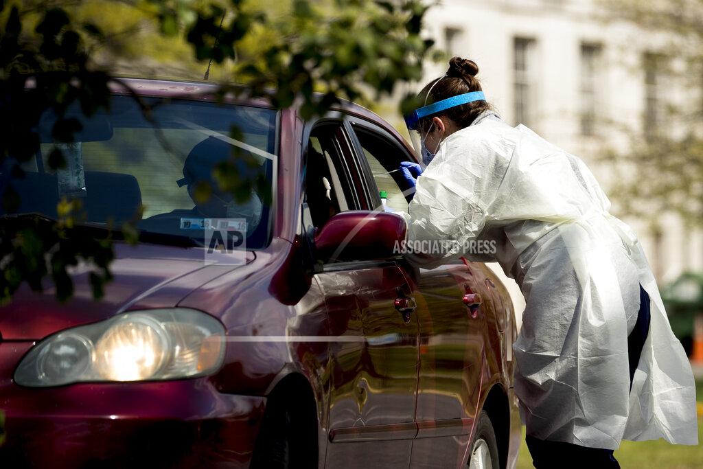 Andrew Harnik A medical worker tests a young man for COVID-19 at a Children's National Hospital drive-through (drive-in) coronavirus testing site at Trinity University, Thursday, April 16, 2020, in Washington. (AP Photo/Andrew Harnik)