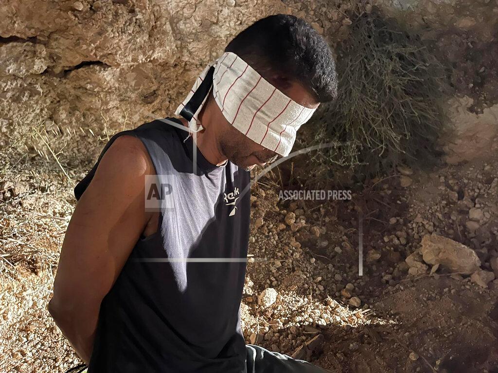 Uncredited In this photo provided by Israel Police, Zakaria Zubeidi, one of the six Palestinians who escaped from a high-security prison earlier this week, is blindfolded after being recaptured in the Arab town of Umm al-Ghanam, northern Israel, Saturday, Sept. 11, 2021. Israeli police on Saturday said they have arrested four of the six Palestinians who broke out of a maximum-security prison this week including Zubeidi, a famed militant leader whose exploits over the years have made him a well-known figure in Israel. (Israeli Police via AP)